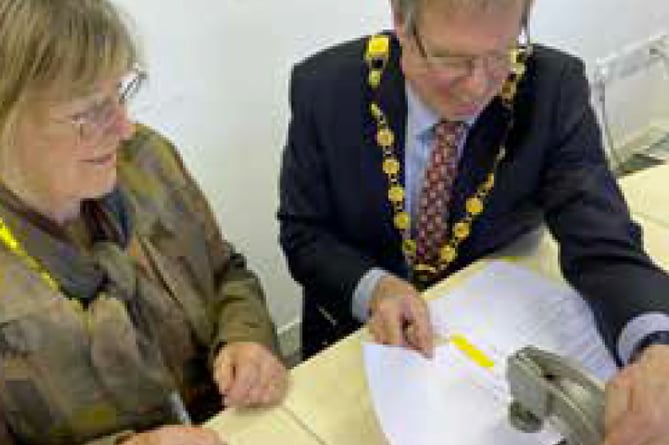 Anna Hocking and Petersfield town mayor Peter Clist use the Petersfield official seal, February 2023.