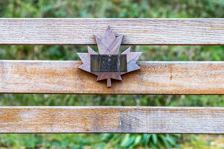 A plaque on a bench - commemorating Canadian 418 soldiers who died in both World Wars. October 22 2023.  Photo released October 27 2023. See SWNS story SWLNmaples. Stunning photos show autumnal red maple trees dotted along a motorway - commemorating Canadian 418 soldiers who gave their lives during war. Many motorists are unaware they are passing through a treasured war memorial on the A3 in Hampshire.A total of 418 of these maples, Canadaâs national tree, were placed along the A3 near Liphook to mark the lives of 418 Canadian servicemen who died in both World Wars. The servicemen trained locally and died at Bramshott during both wars.There was a Canadian training base in the area, as well as a large hospital caring for sick and wounded soldiers.