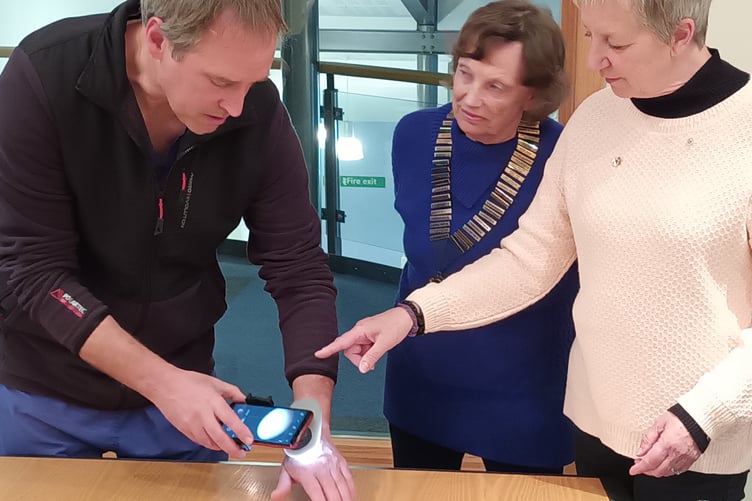 Dr Jules Barber demonstrates a dermatoscope to Alton Lions Club members Moira Baker, left, and Frances Parris, November 1st 2023.