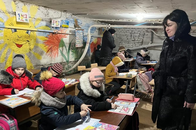 Children taking a school lesson in a shelter in Ukraine. 