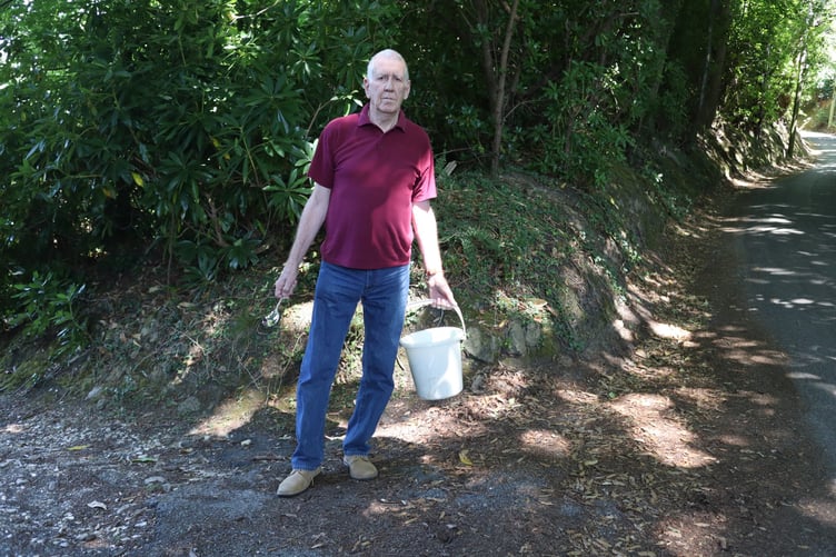 Barry McGerr on Chase Lane with a bucket and teaspoon – a nod to a Thames Water driver’s claim that supplying Haslemere's reservoir is “like filling a bucket with a teaspoon.”