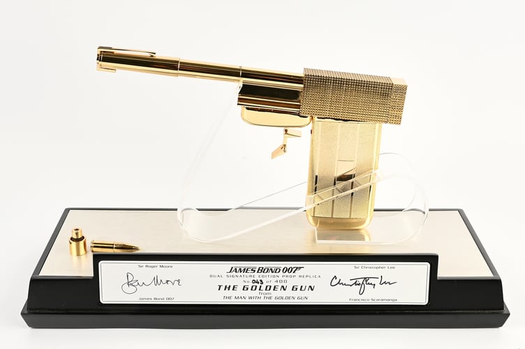 A replica of the Golden Gun from The Man with the Golden Gun, signed by Sir Roger Moore and Sir Christopher Lee.