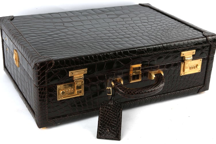 An Asprey London shiny alligator skin train suitcase.