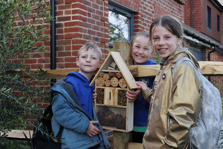 Pupils from St Mary's C of E Primary School Gardening Club help install bug hotels at Elivia Homes' Oakland Grove development in Chiddingfold