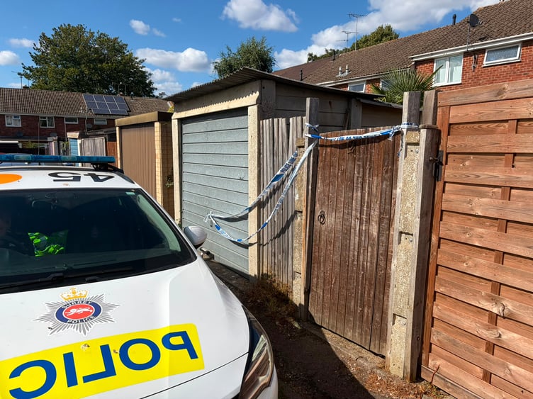 A police car and crime scene tape at a property in Wrecclesham following the death of man.